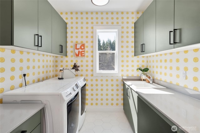 laundry room with cabinet space, light tile patterned floors, wallpapered walls, separate washer and dryer, and a sink