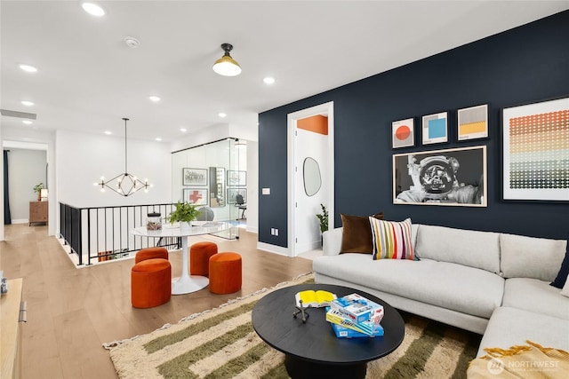 living room featuring recessed lighting, visible vents, an inviting chandelier, and wood finished floors