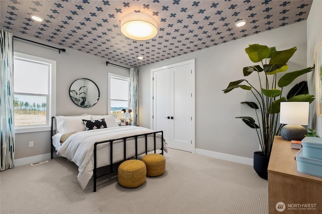 bedroom featuring multiple windows, visible vents, and baseboards