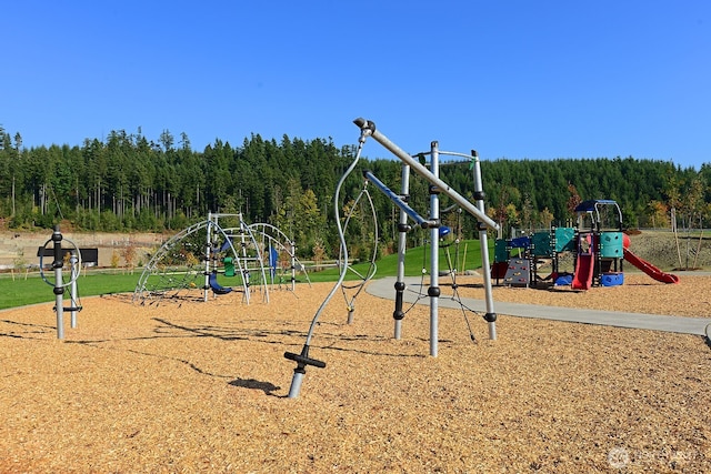 community jungle gym with a wooded view