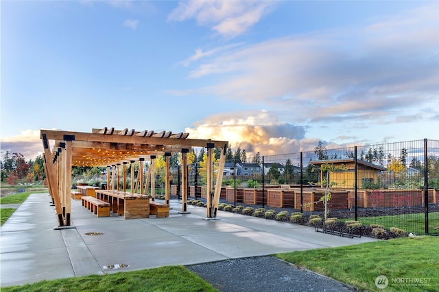 view of property's community with a garden, a pergola, and a patio