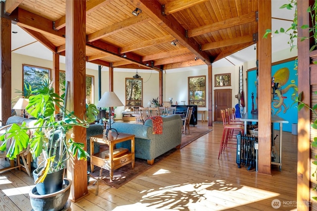 living area with hardwood / wood-style floors, wooden ceiling, and beamed ceiling