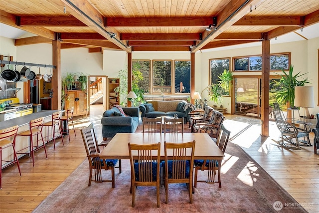 dining area featuring wood-type flooring, beam ceiling, wooden ceiling, and stairs