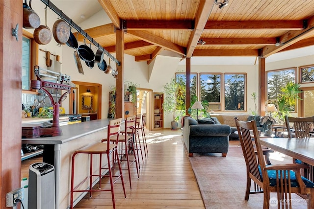 dining room featuring beamed ceiling, wood ceiling, and wood-type flooring