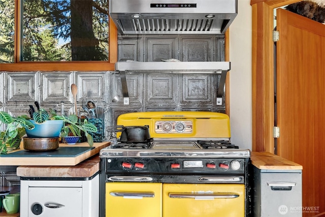 interior space with ventilation hood and range with two ovens