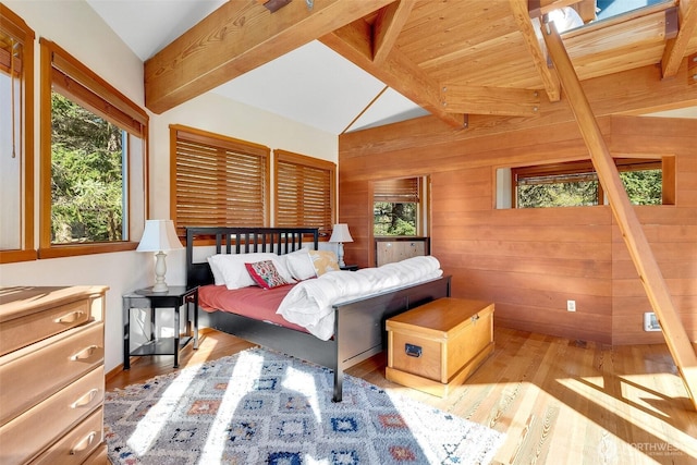 bedroom with wood finished floors, wood walls, and vaulted ceiling with beams