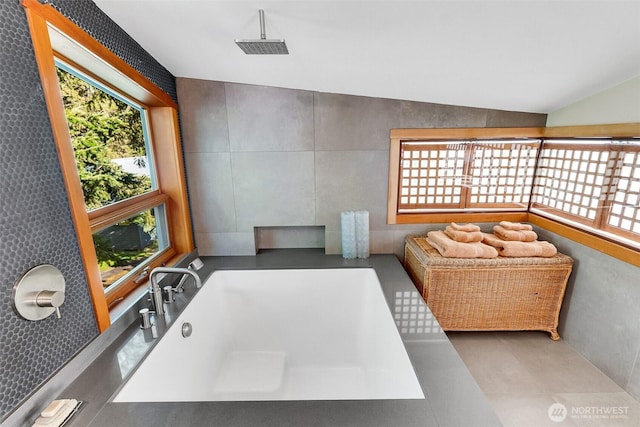 bathroom with vaulted ceiling and a wealth of natural light