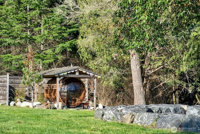 view of outdoor structure featuring an outbuilding and a wooded view