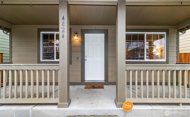 view of exterior entry featuring covered porch