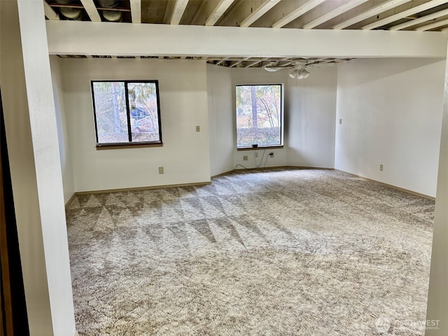 carpeted empty room featuring baseboards