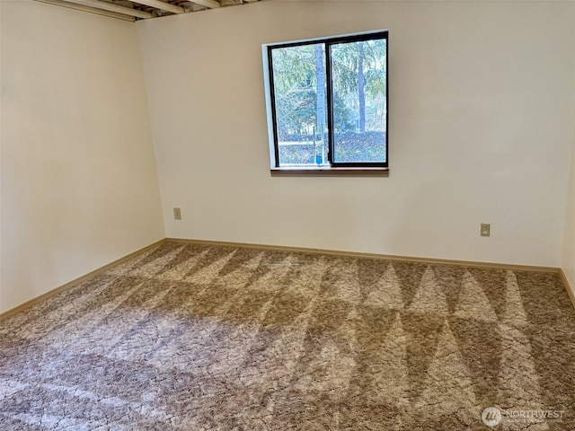 carpeted empty room with baseboards