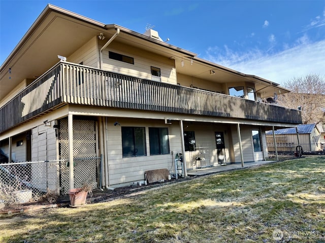 back of property with a chimney, a lawn, a patio area, and fence