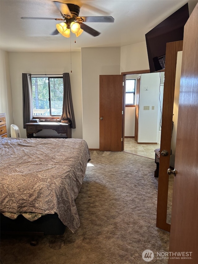 carpeted bedroom featuring multiple windows and a ceiling fan