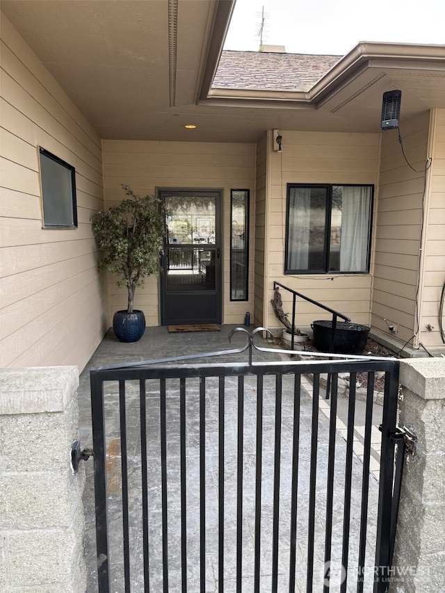 entrance to property with a shingled roof