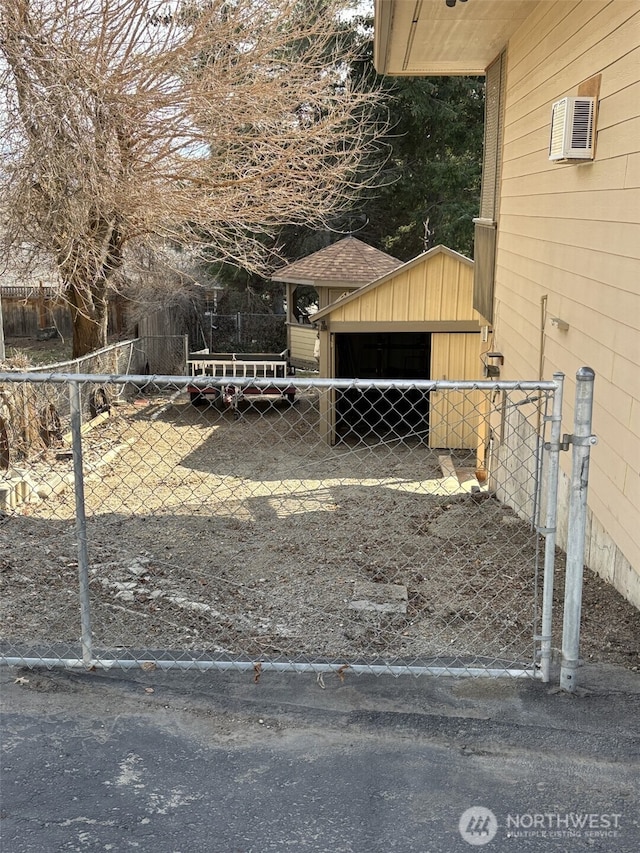 exterior space with an outbuilding, a gate, and fence