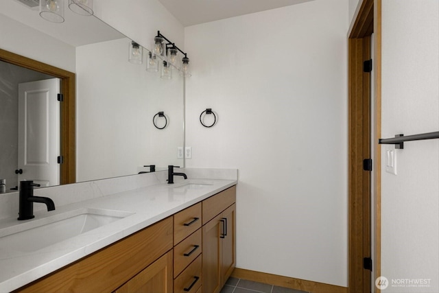 bathroom featuring tile patterned flooring, a sink, baseboards, and double vanity