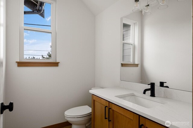 half bathroom featuring vanity and toilet