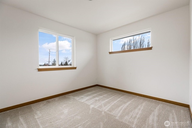 unfurnished room with carpet floors, a wealth of natural light, and baseboards