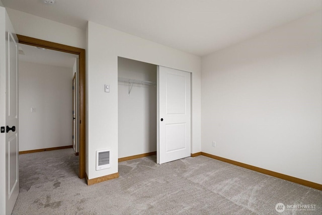 unfurnished bedroom featuring baseboards, a closet, visible vents, and carpet flooring