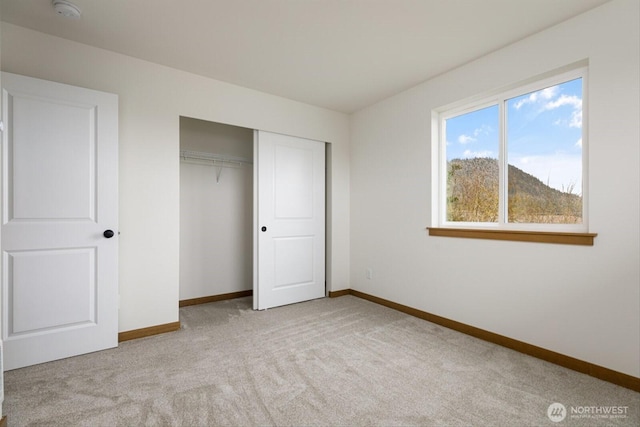 unfurnished bedroom with a closet, carpet flooring, and baseboards