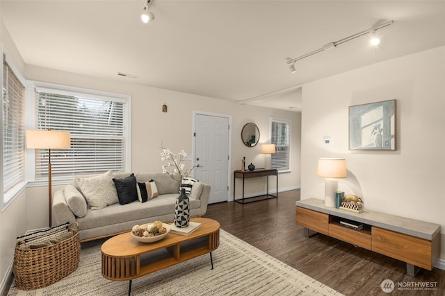 living room featuring baseboards, track lighting, visible vents, and wood finished floors