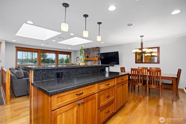 kitchen featuring brown cabinetry, recessed lighting, open floor plan, and light wood finished floors