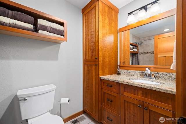 full bathroom featuring baseboards, visible vents, toilet, a tile shower, and vanity