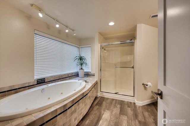 full bathroom with visible vents, a shower stall, a whirlpool tub, and wood finished floors