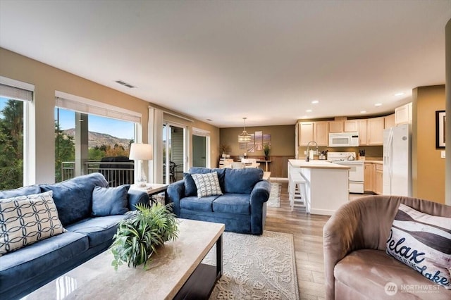 living area featuring light wood finished floors, visible vents, and recessed lighting