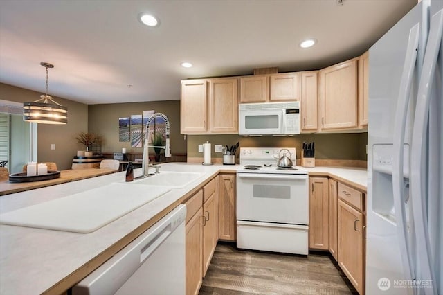 kitchen featuring recessed lighting, white appliances, light brown cabinets, and a sink