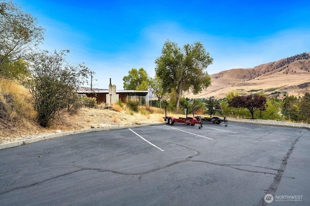 uncovered parking lot featuring a mountain view