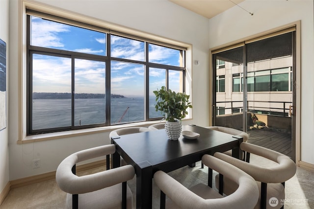 carpeted dining room featuring baseboards