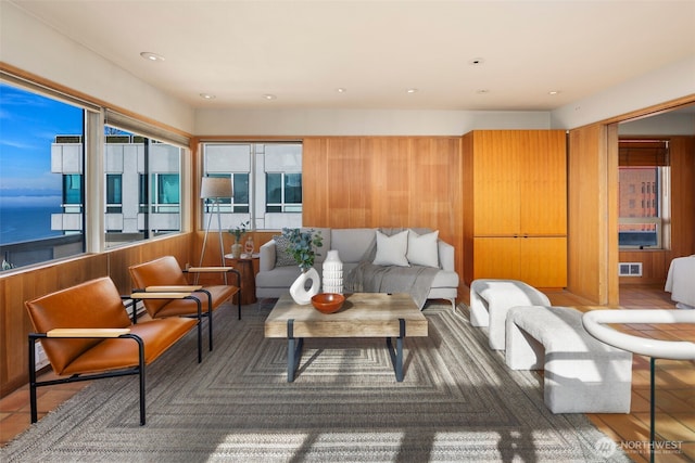 living area featuring recessed lighting, visible vents, and a water view