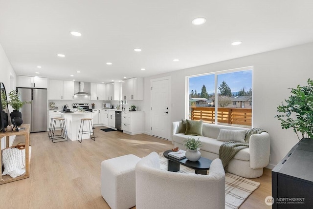 living room with baseboards, recessed lighting, and light wood-style floors