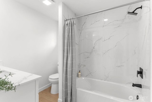 bathroom with shower / bath combo, baseboards, toilet, wood finished floors, and vanity