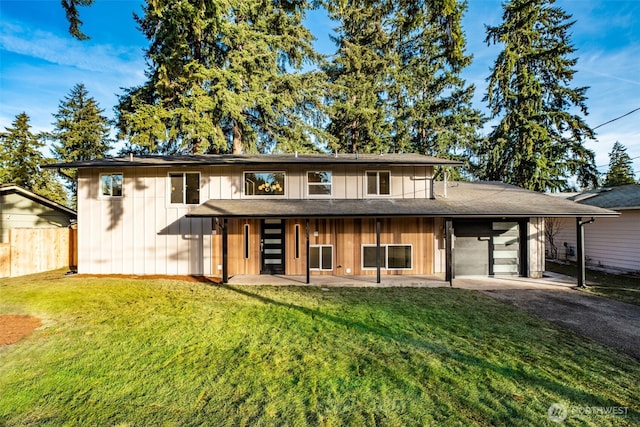 view of front of property with aphalt driveway, fence, board and batten siding, and a front lawn