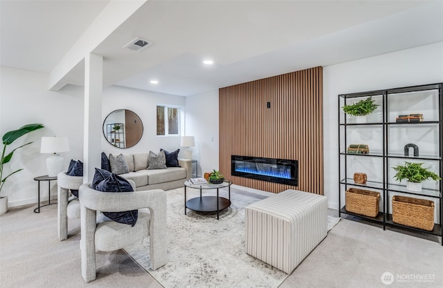 carpeted living area with baseboards, visible vents, a glass covered fireplace, and recessed lighting