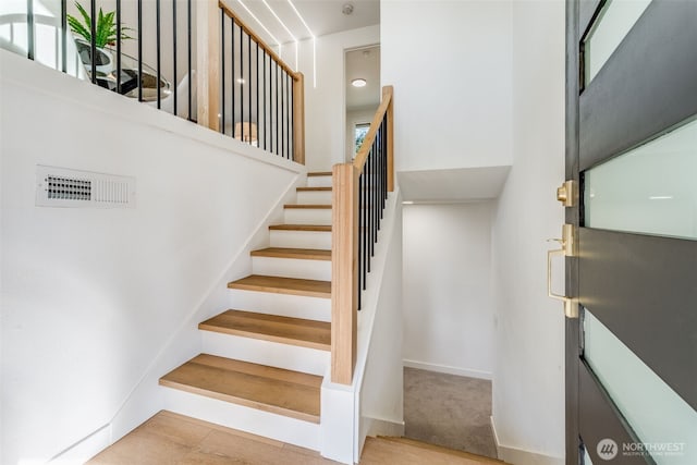 staircase featuring carpet floors, baseboards, and visible vents