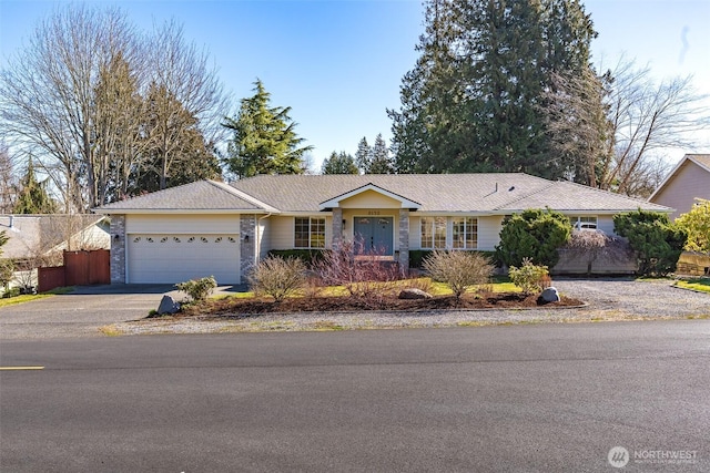 single story home featuring an attached garage, fence, and aphalt driveway