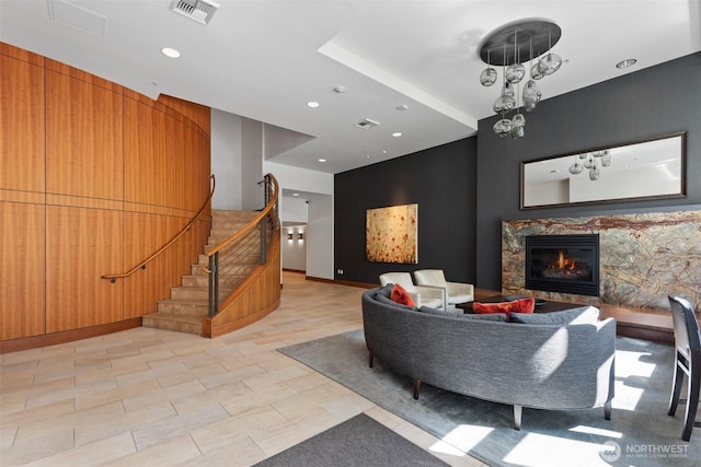 living room featuring stairway, recessed lighting, visible vents, and a high end fireplace