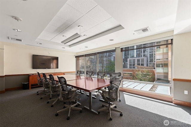 dining area with carpet floors, visible vents, and a raised ceiling