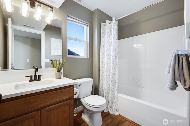 full bath featuring toilet, wood finished floors, vanity, visible vents, and shower / bath combo with shower curtain