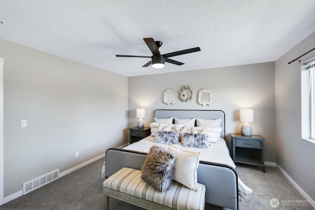 carpeted bedroom featuring a textured ceiling, a ceiling fan, visible vents, and baseboards