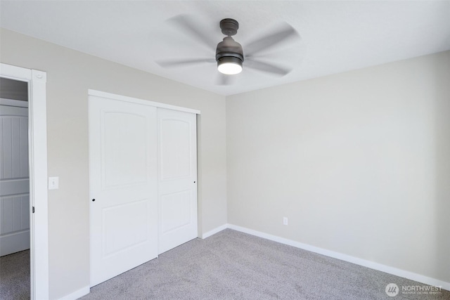 unfurnished bedroom with carpet floors, a closet, ceiling fan, and baseboards