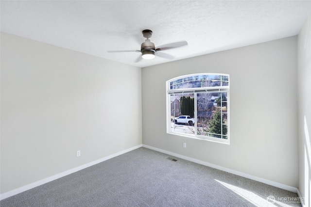 unfurnished room featuring carpet flooring, ceiling fan, visible vents, and baseboards