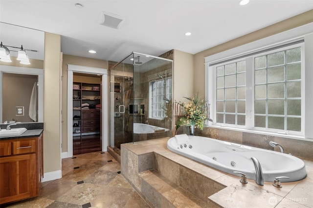 bathroom featuring a whirlpool tub, a spacious closet, a stall shower, and vanity