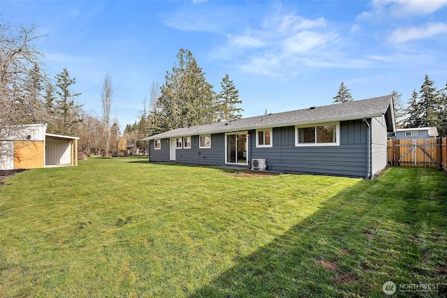 back of house with a yard, an outbuilding, fence, and board and batten siding