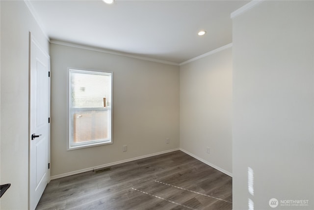 spare room featuring baseboards, crown molding, visible vents, and wood finished floors