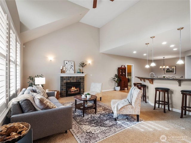 carpeted living area featuring high vaulted ceiling, a fireplace, a ceiling fan, and baseboards