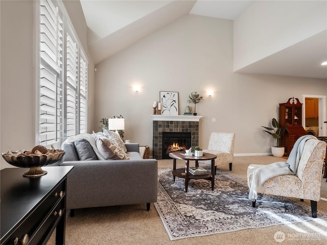 living room featuring high vaulted ceiling, baseboards, and a tiled fireplace